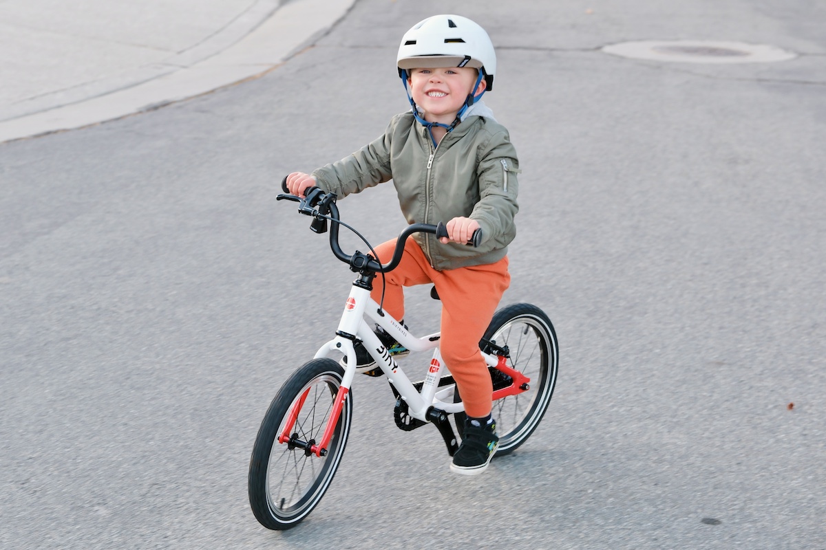 3 year old riding the Biky 16 while smiling