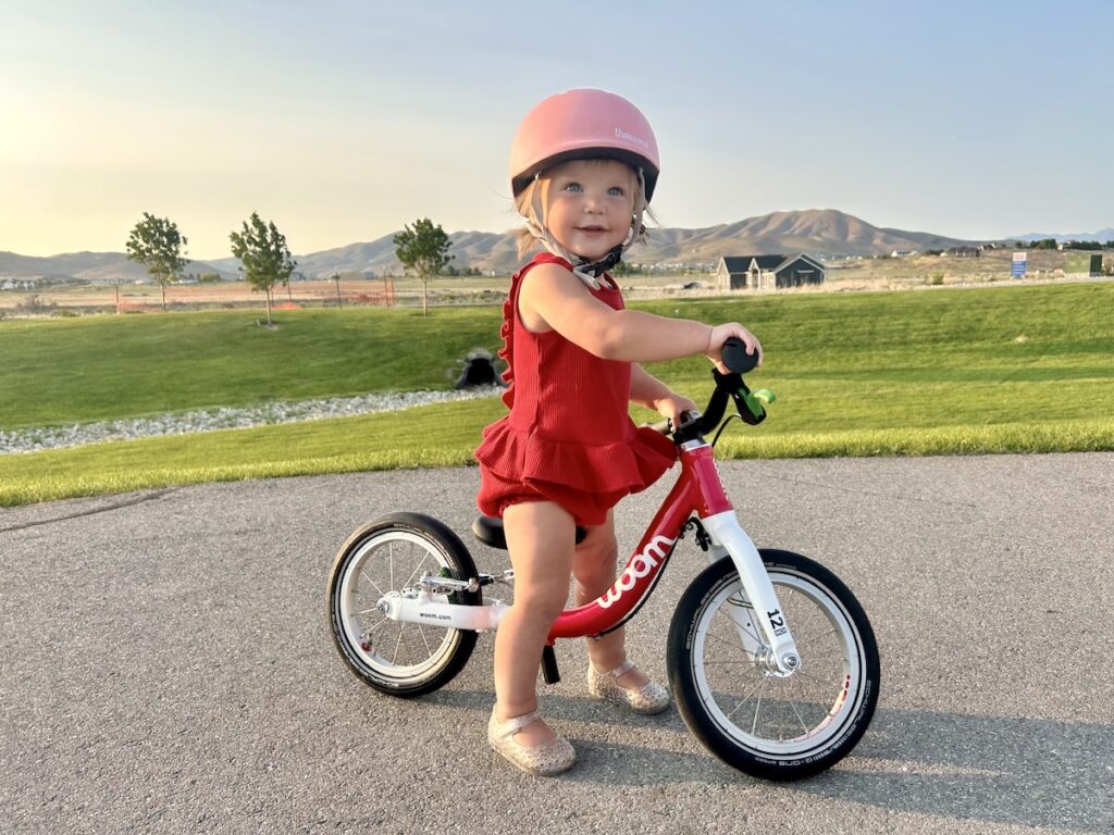 woom GO 1 balance bike ridden by a toddler girl