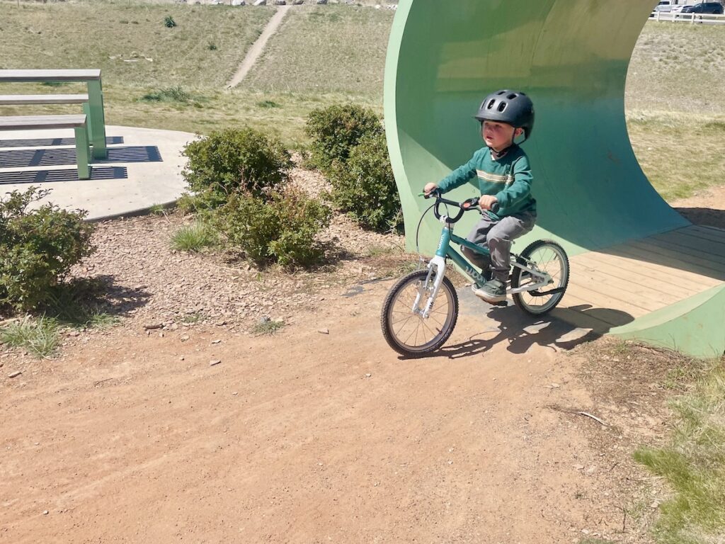 preschooler riding the woom 3 through a tube