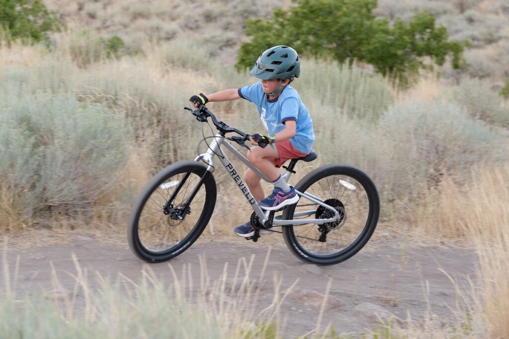 rider on three Prevelo Alpha Four going up a hill