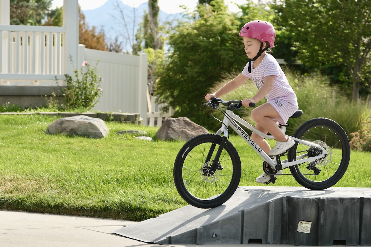 girl riding the prevelo 20 inch bike down a bike ramp