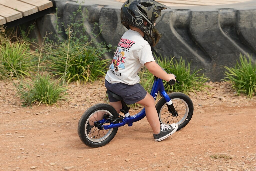 child on the Prevelo alpha zero running in the dirt