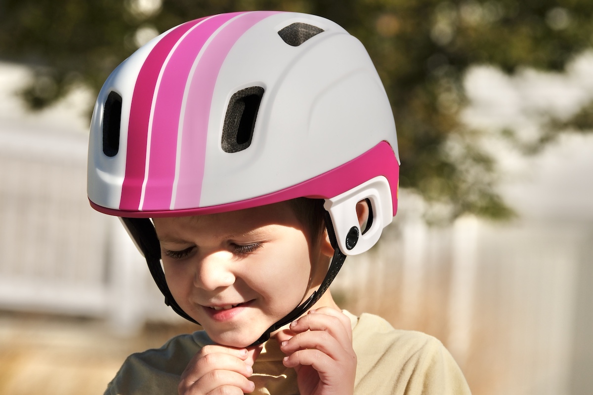 child wearing a bike helmet with the HighBar chin strap system