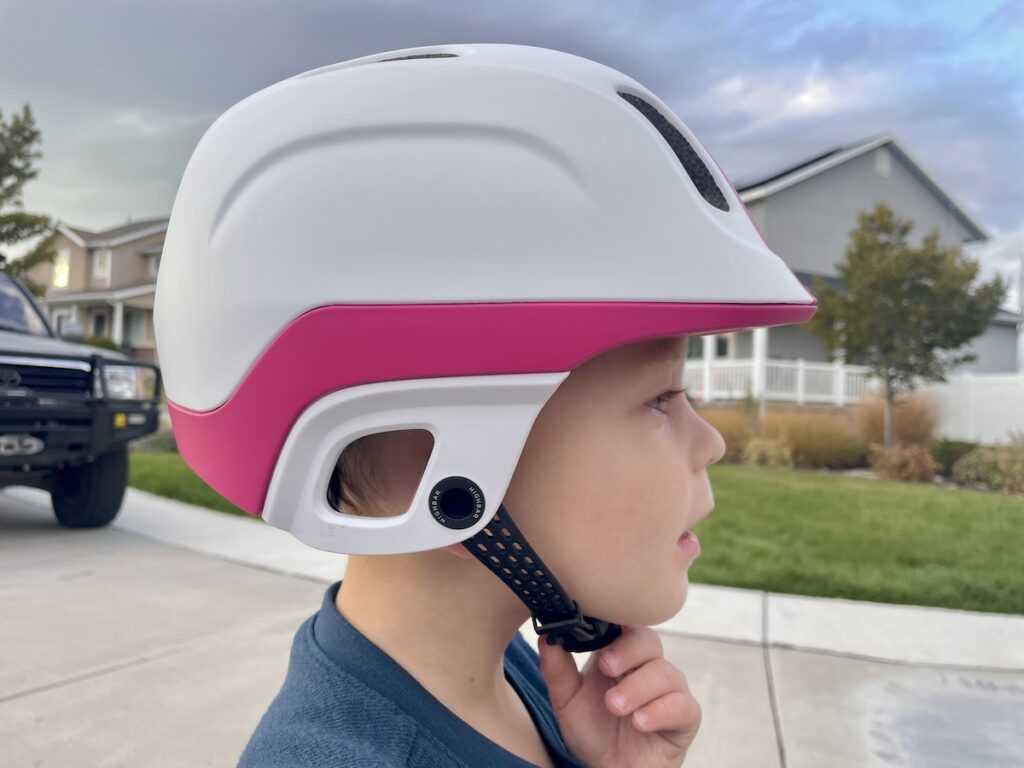 child adjusting the Highbar helmet himself