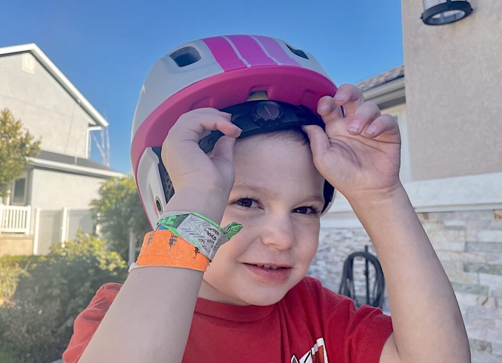 Child putting on a Highbar helmet by themselves