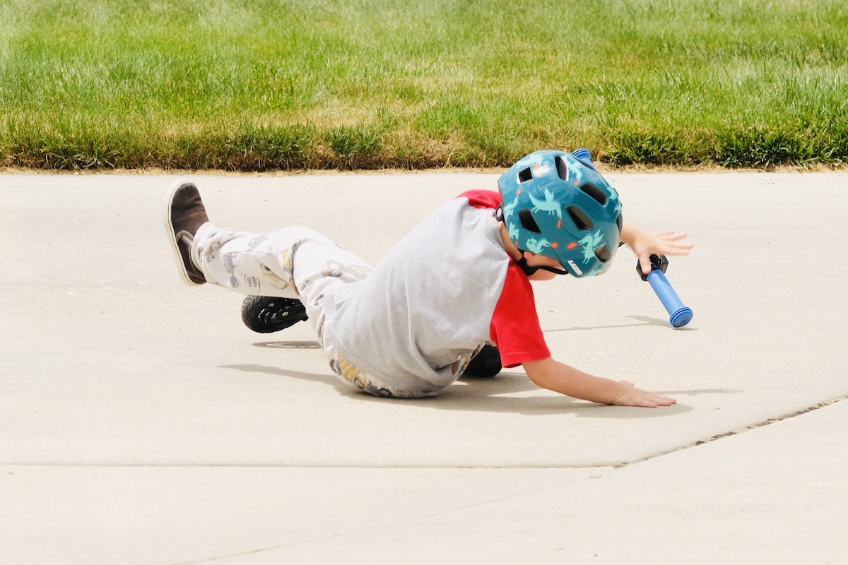 child crashing on an electric scooter